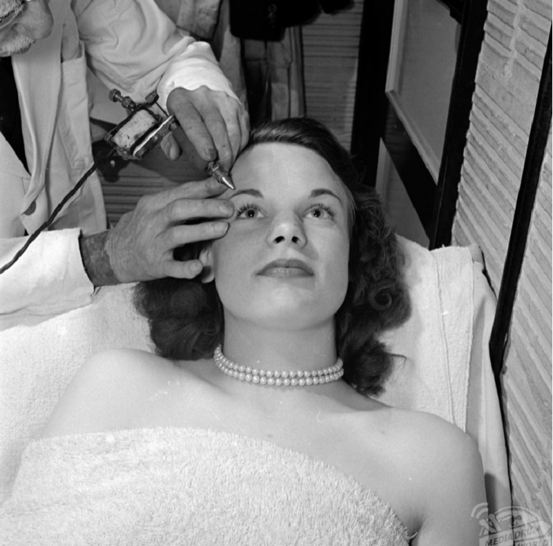 Hình ảnh một người phụ nữ thực hiện xăm chân mày vào thập niên 1940.